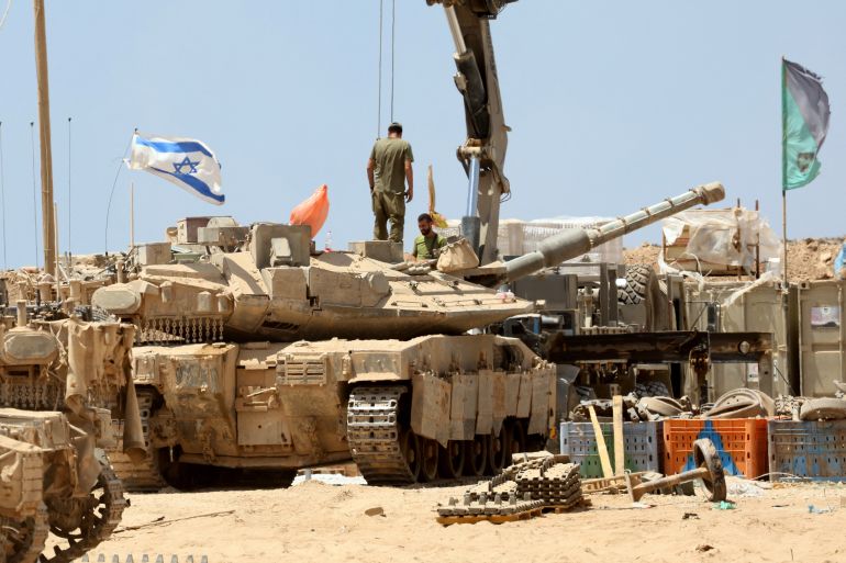 ضغوط أوروبية متصاعدة تهدد مكانة الصناعة العسكرية بإسرائيل 2 Israeli troops deploy with their tanks near the border fence with the Gaza Strip on August 1, 2025. (Photo by Jack GUEZ / AFP)