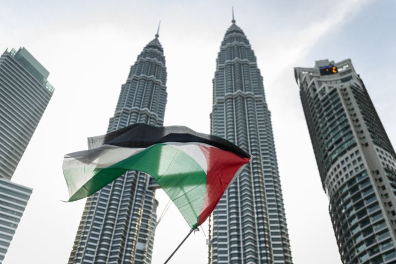 إدانة ماليزية شعبية ورسمية لجرائم التجويع في غزة 3 KUALA LUMPUR, MALAYSIA - AUGUST 02: A pro-Palestinian protester waves a Palestinian flag in front of the Petronas Twin Towers during a march to express solidarity with the people of Palestine on August 2, 2025 in Kuala Lumpur, Malaysia. Protesters in Malaysia joined marches and actions globally, as pressure mounts on the Israeli government over a devastating humanitarian crisis unfolding as its war against Hamas continues. (Photo by Annice Lyn/Getty Images)