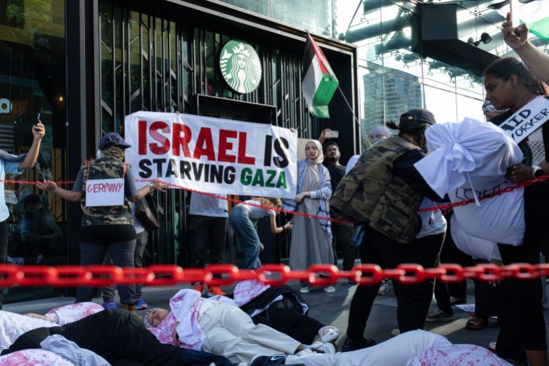 إدانة ماليزية شعبية ورسمية لجرائم التجويع في غزة 1 KUALA LUMPUR, MALAYSIA – AUGUST 02: Pro-Palestinian protesters perform a protest in front of a Starbucks, highlighting the ongoing crisis in Gaza during a march to express solidarity with the people of Palestine on August 2, 2025 in Kuala Lumpur, Malaysia. Protesters in Malaysia joined marches and actions globally, as pressure mounts on the Israeli government over a devastating humanitarian crisis unfolding as its war against Hamas continues. (Photo by Annice Lyn/Getty Images)