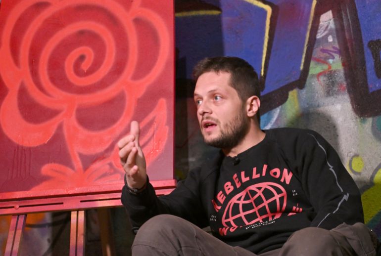 فن الشارع في سراييفو: جسور من الألوان في مواجهة الانقسامات القومية 3 Bosnian street artist Benjamin Cengic sits next to his signature 'Flower Graffitti' in his creative space, in Sarajevo on May 22, 2025. (Photo by ELVIS BARUKCIC / AFP)