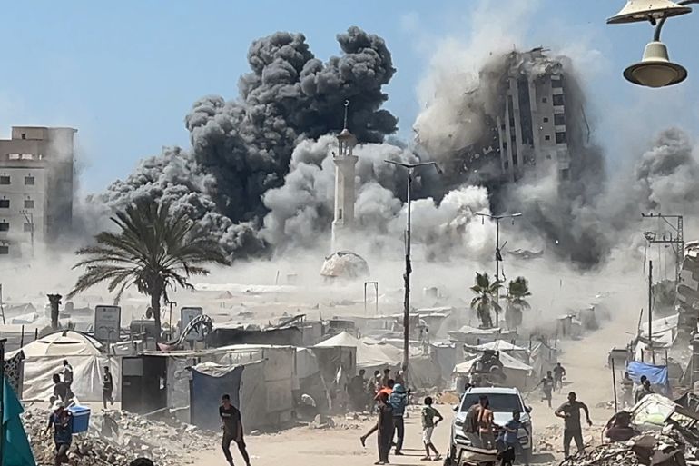 ماذا وراء استهداف إسرائيل الأبراج السكنية بغزة؟ 3 1-تصاعد سحب الدخان والغبار الكثيف لحظة انهيار برج مشتهى وسط مدينة غزة، بعد استهدافه المباشر من الطائرات الإسرائيلية.